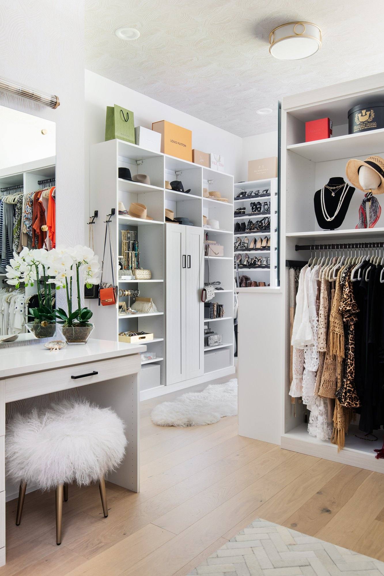 Closet with a built-in vanity desk and stool, open shelving, accessory hooks and hanging space